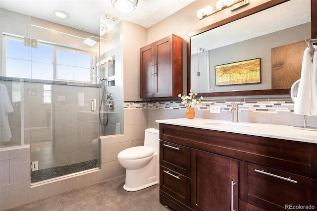 6868 S Birch Way, Centennial, CO 80122 - full bath featuring vanity, tile patterned flooring, a shower stall, tile walls, and backsplash