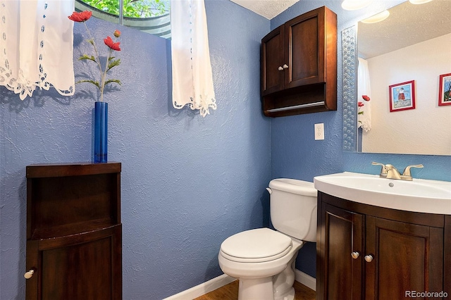 6868 S Birch Way, Centennial, CO 80122 - half bathroom featuring vanity, wood finished floors, and a textured wall