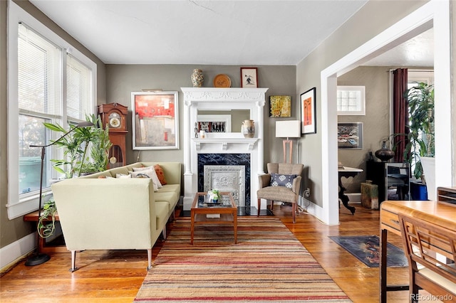 sitting room with light wood-type flooring and a high end fireplace