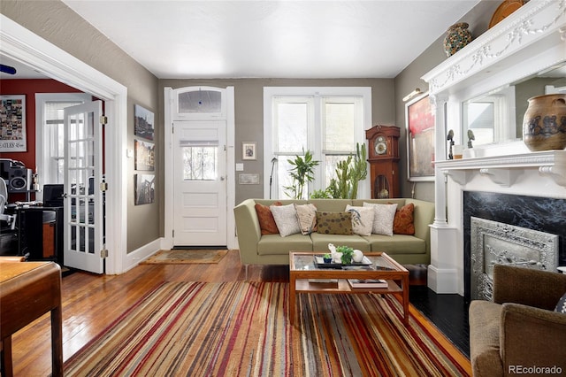 living room featuring wood-type flooring and a high end fireplace