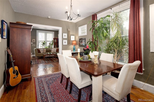 dining room with dark hardwood / wood-style floors and a chandelier