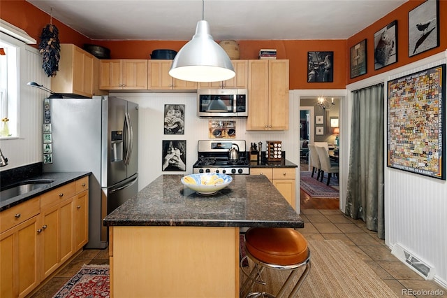 kitchen with stainless steel appliances, light tile patterned floors, decorative light fixtures, a center island, and a breakfast bar area