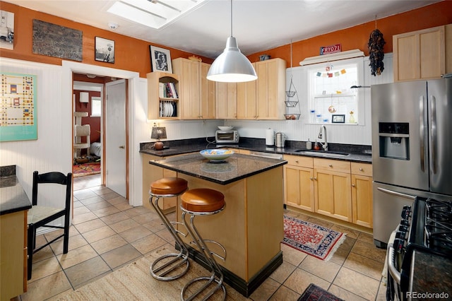 kitchen with a kitchen bar, a wealth of natural light, a center island, and stainless steel appliances