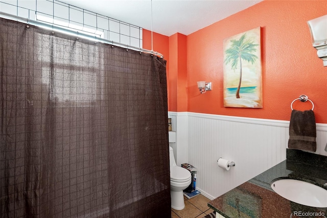 bathroom featuring tile patterned floors, vanity, curtained shower, and toilet