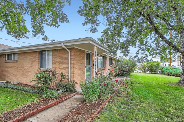 5563 Newland Way, Arvada, CO 80002 - view of side of home featuring a lawn and brick siding