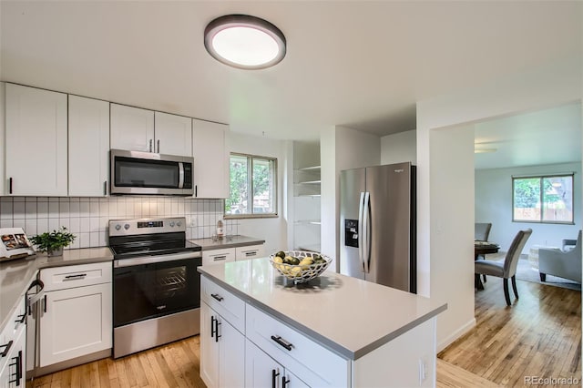 5563 Newland Way, Arvada, CO 80002 - kitchen with stainless steel appliances, light wood-type flooring, plenty of natural light, and backsplash