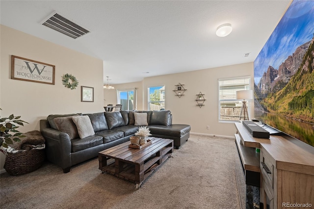 living room with carpet flooring and an inviting chandelier