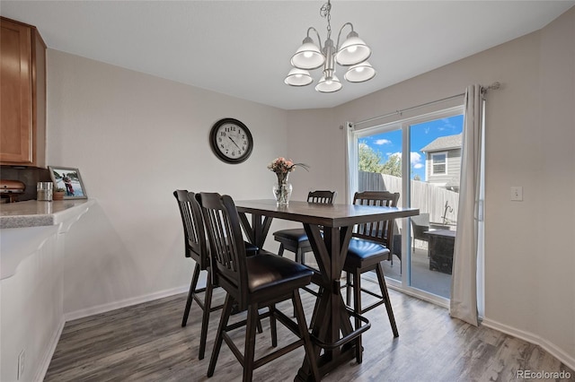 dining room with hardwood / wood-style floors and a notable chandelier