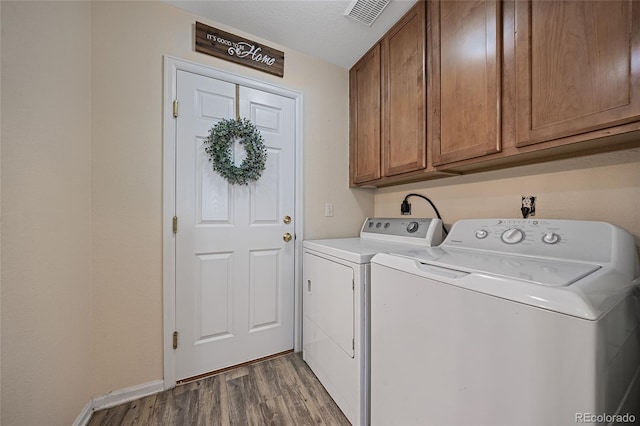 washroom with washer and clothes dryer, dark wood-type flooring, cabinets, and a textured ceiling