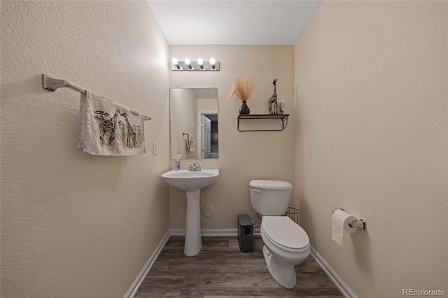 bathroom with hardwood / wood-style flooring, toilet, and sink