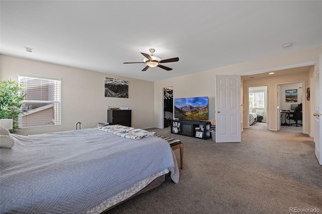 carpeted bedroom featuring multiple windows and ceiling fan