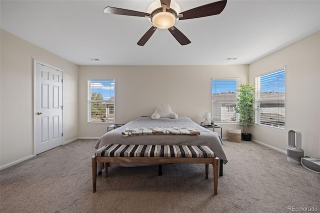 carpeted bedroom featuring ceiling fan and multiple windows