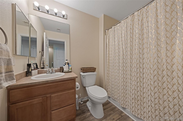 bathroom featuring hardwood / wood-style flooring, vanity, toilet, and walk in shower