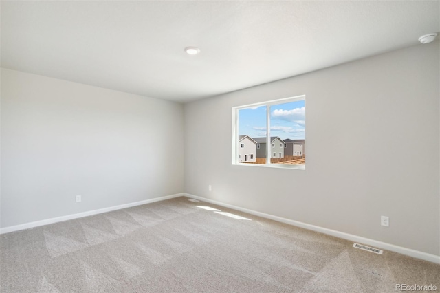 unfurnished room with carpet floors and baseboards