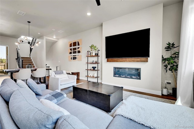 1575 W 68th Ave, Denver, CO 80221 - living room with a chandelier, recessed lighting, stairway, wood finished floors, and a glass covered fireplace