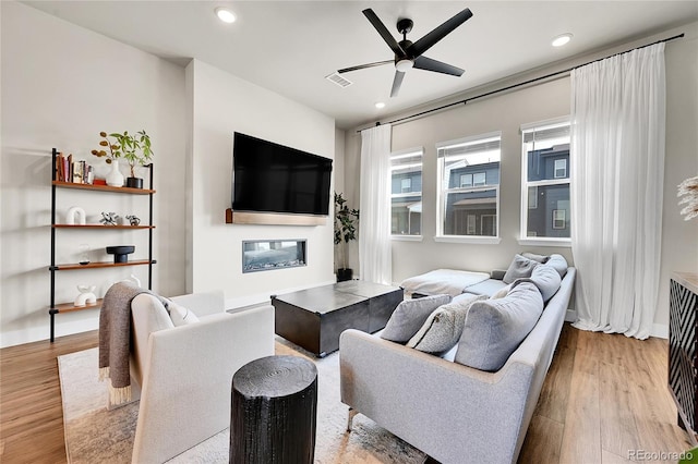 1575 W 68th Ave, Denver, CO 80221 - living area with a ceiling fan, wood finished floors, a glass covered fireplace, and recessed lighting