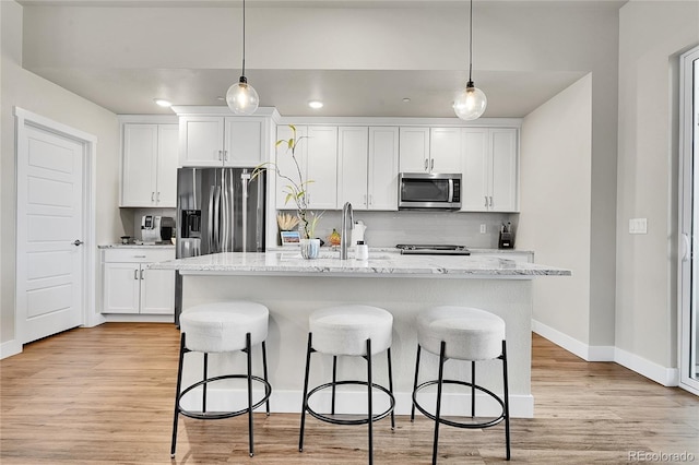 1575 W 68th Ave, Denver, CO 80221 - kitchen with stainless steel appliances, a breakfast bar, white cabinetry, backsplash, and recessed lighting