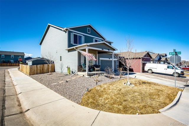 traditional-style home featuring a garage, concrete driveway, and fence