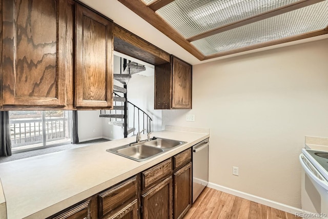 kitchen featuring dishwasher, white electric range, light wood-type flooring, and sink