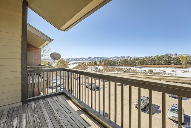 snow covered back of property featuring a mountain view