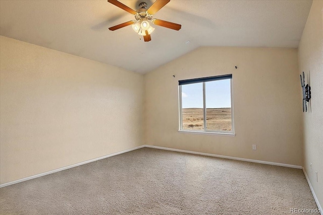 spare room featuring carpet, vaulted ceiling, baseboards, and ceiling fan