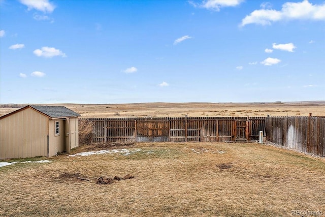 exterior space featuring a storage shed, a fenced backyard, and an outbuilding