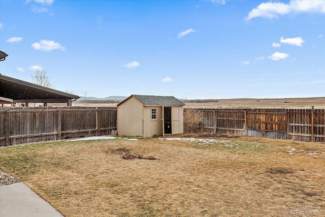 view of yard featuring an outbuilding, a fenced backyard, and a storage shed