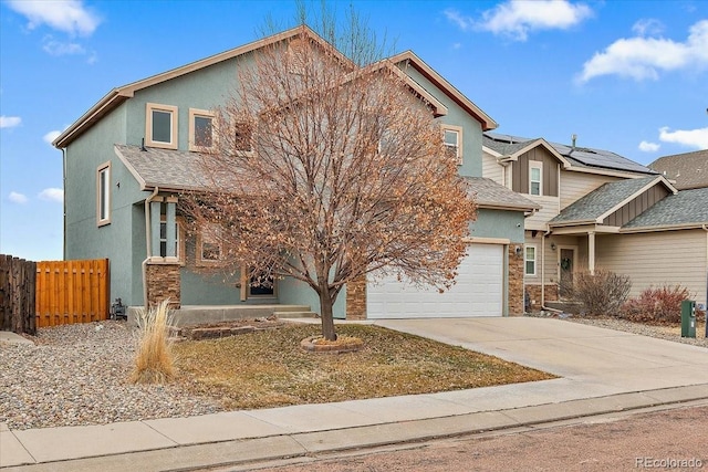 view of front of house with a garage, concrete driveway, fence, and stucco siding