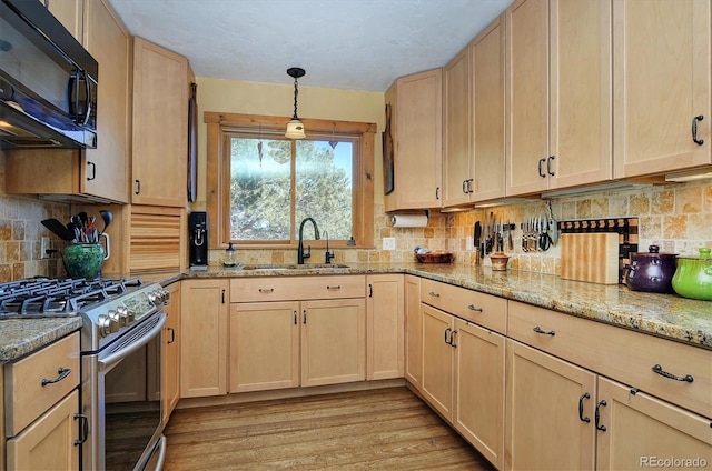 kitchen featuring tasteful backsplash, stainless steel gas range oven, sink, and light brown cabinets