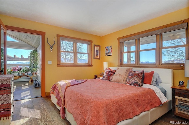 bedroom with a water view and hardwood / wood-style floors