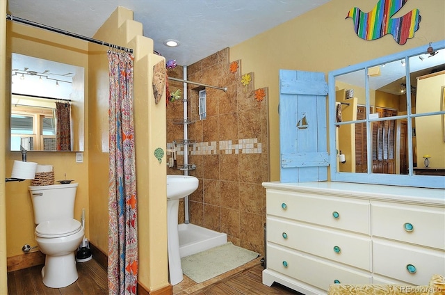 bathroom featuring wood-type flooring, toilet, and a shower with shower curtain