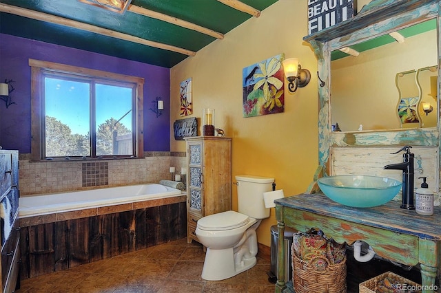 bathroom featuring vanity, tile patterned floors, tiled bath, and toilet