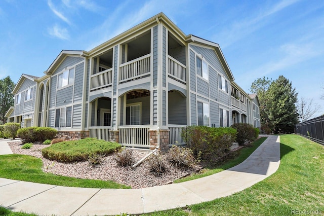 view of property exterior with a yard, a porch, and a balcony