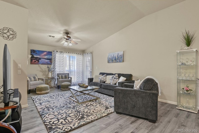 living room featuring a ceiling fan, vaulted ceiling, wood finished floors, and visible vents