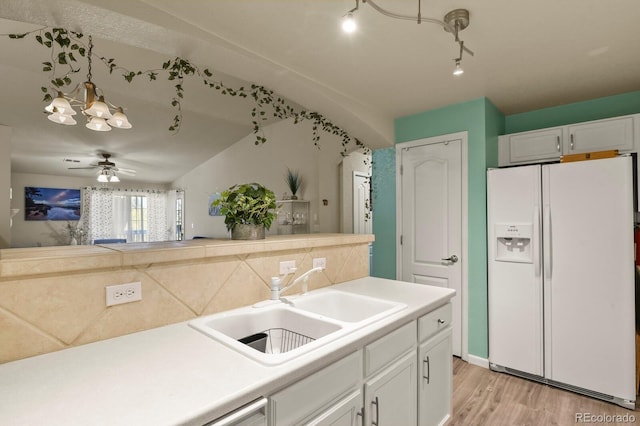 kitchen with light wood-type flooring, a sink, light countertops, white cabinets, and white fridge with ice dispenser