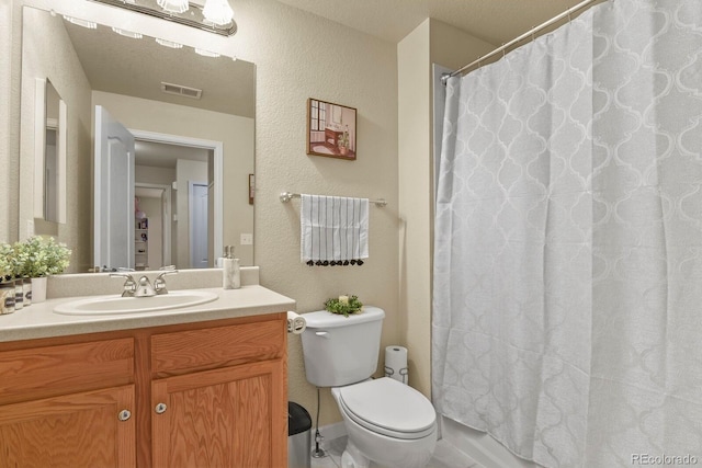 bathroom featuring a textured wall, vanity, toilet, curtained shower, and visible vents