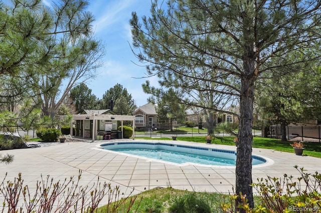 pool with a pergola, fence, and a patio area