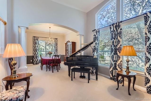 sitting room with ornate columns, an inviting chandelier, a wealth of natural light, and arched walkways