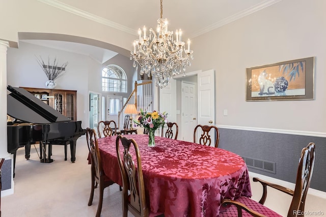 dining space with ornamental molding, visible vents, arched walkways, and carpet