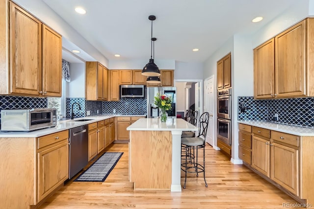 kitchen with a kitchen breakfast bar, a center island, backsplash, stainless steel appliances, and a sink