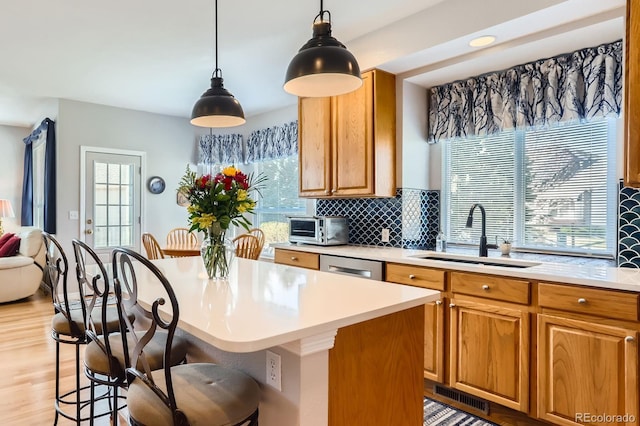 kitchen with a kitchen bar, tasteful backsplash, visible vents, light countertops, and a sink