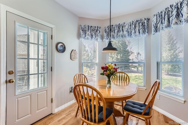 dining area featuring light wood-style flooring and baseboards