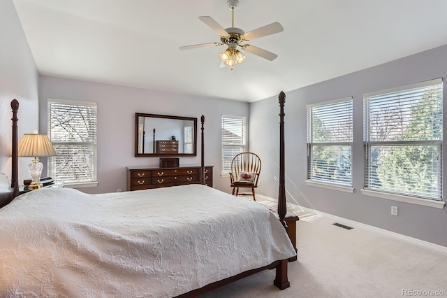 carpeted bedroom with visible vents, baseboards, multiple windows, and a ceiling fan