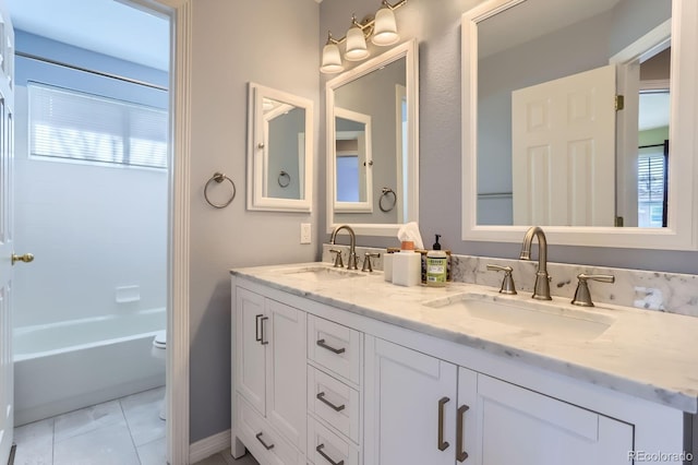 full bathroom with a sink, tile patterned floors, double vanity, and toilet