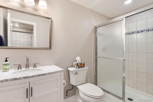 full bath featuring vanity, a stall shower, and toilet
