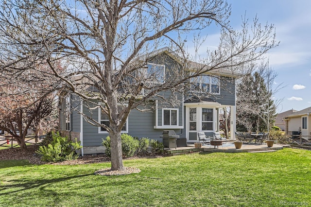 back of property with a yard and a patio area