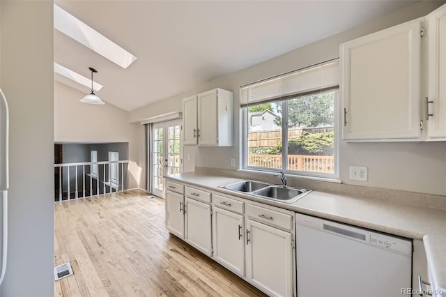 1758 S Ensenada St, Aurora, CO 80017 - kitchen featuring white dishwasher, a sink, a skylight, vaulted ceiling, and white cabinetry