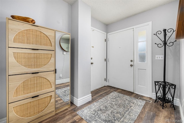 entrance foyer with visible vents, a textured ceiling, baseboards, and wood finished floors