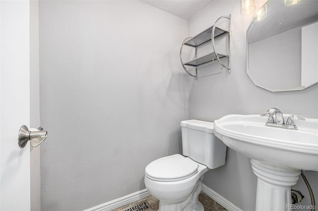 bathroom with toilet and baseboards