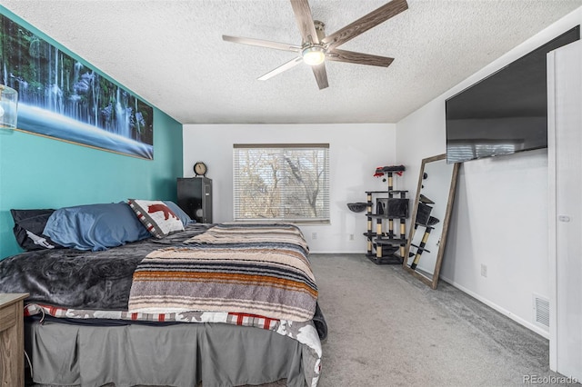 bedroom with a textured ceiling, visible vents, baseboards, a ceiling fan, and carpet